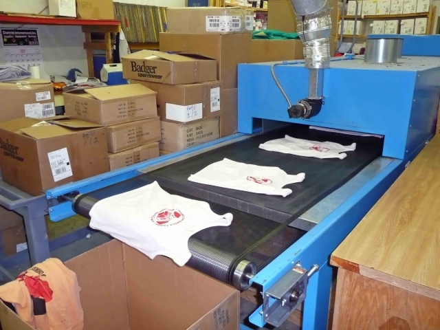 This machines dries the logos onto the shirts. These are not the ones we ordered, but they could be. Ours had already been produced.